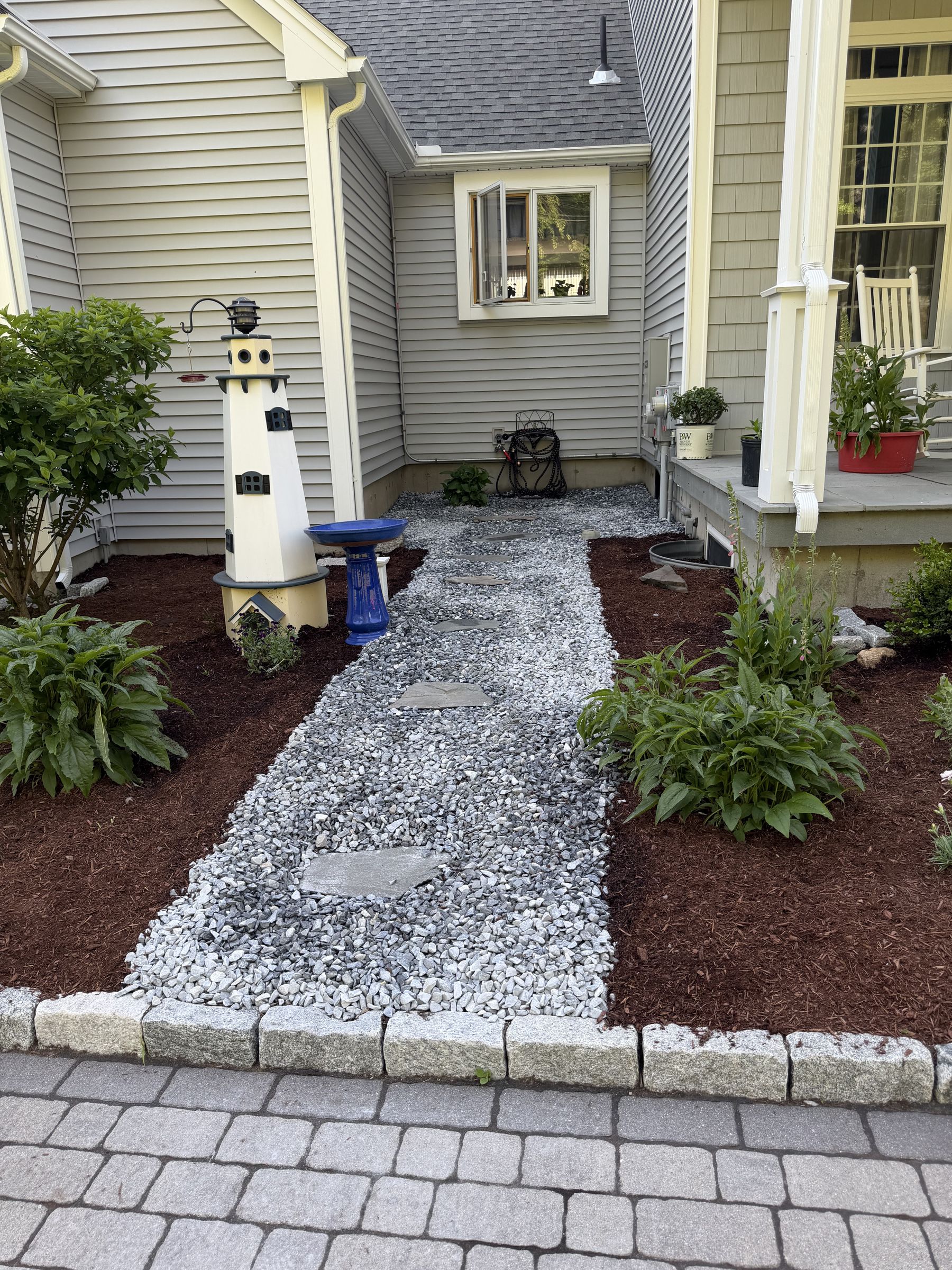Decorative rock walkway with fresh mulch beds