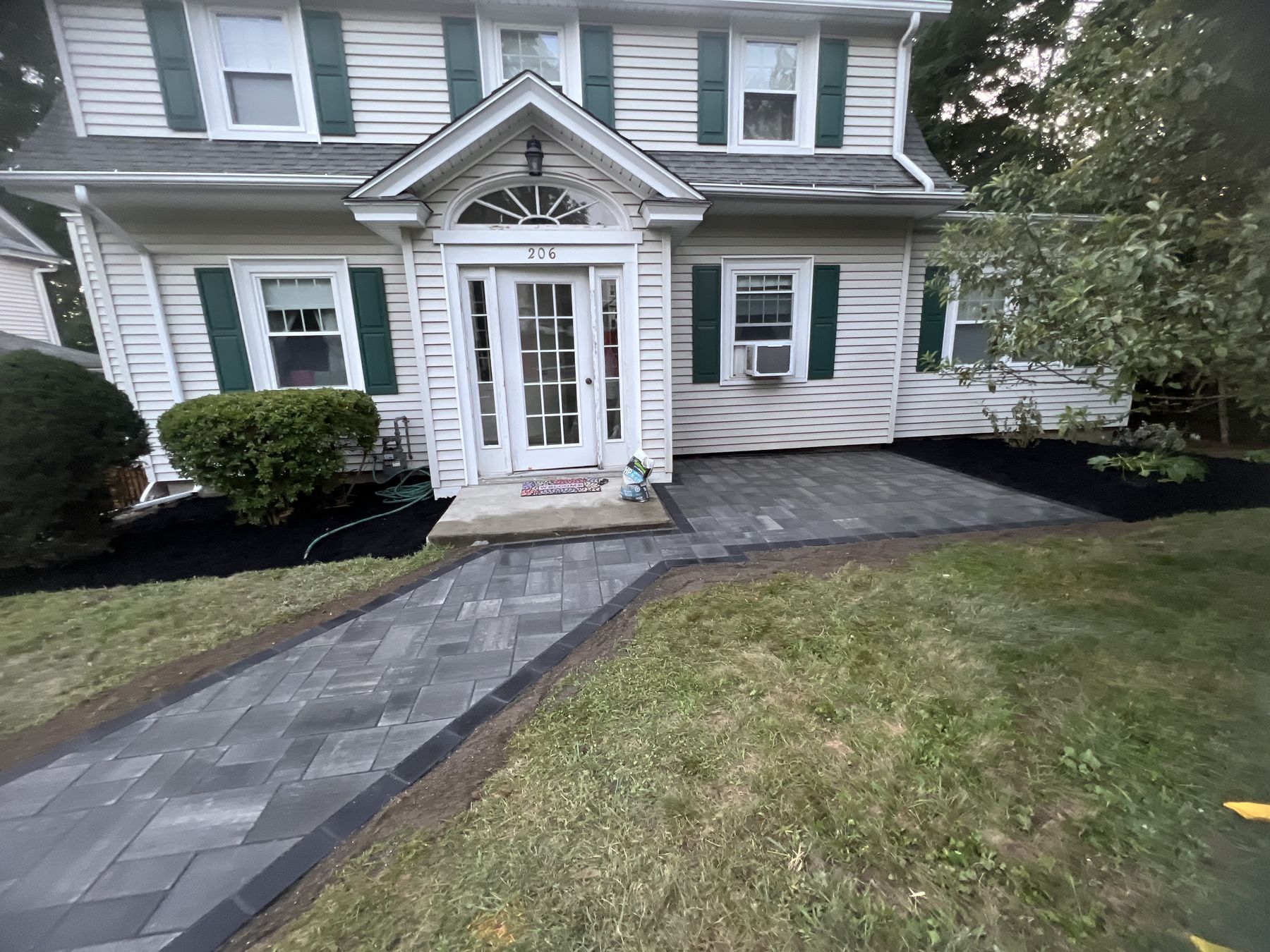 Home with new paver walkway and fresh landscaping